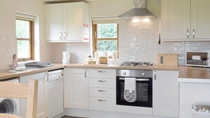 A modern kitchen with white cabinets, a built-in oven, a gas stove, and a microwave.