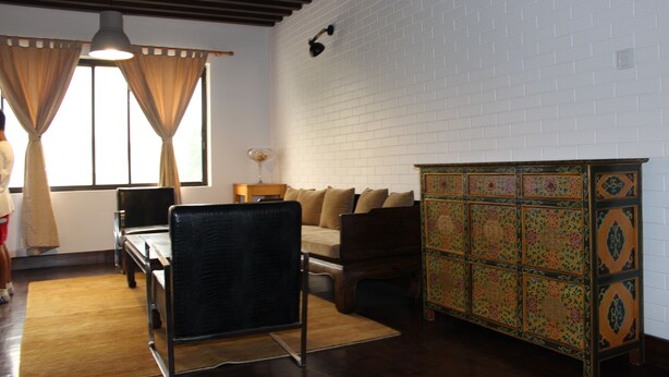 Una sala de estar con un sofá, un mueble de madera y una mesa de comedor.
