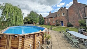 A wooden hot tub, a brick house, and a patio with outdoor furniture. - 8 bedroom accommodation in Horbling, near Sleaford (Horbling, near Sleaford)