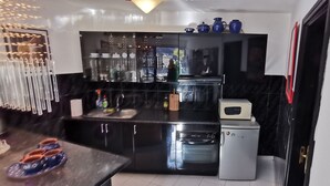 A compact kitchen with black countertops, a built-in oven, and a small refrigerator. - Relax as a couple on the large terrace, view of the mountains, Wi-Fi (Mogan)