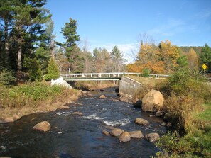 Un río con un puente, rodeado de árboles y rocas.