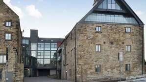 A stone building with a modern glass entrance and a 20 mph speed limit sign. - 2 bedroom accommodation in Alnwick (Alnwick)