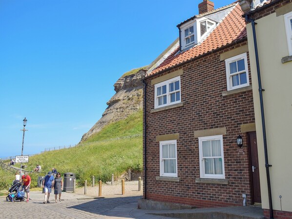 A brick building with a red-tiled roof and a small window. - Captains Cottage - E3643 (Whitby)