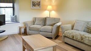 A living room with two sofas, a wooden coffee table, a TV, and a lamp. - 2 bedroom accommodation in Linlithgow, near Edinburgh (Linlithgow, near Edinburgh)