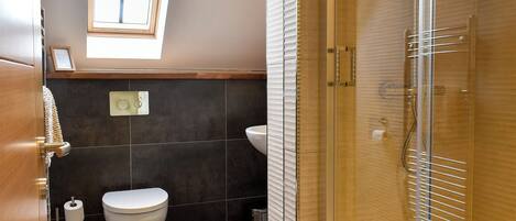 A modern bathroom with a toilet, sink, and shower.