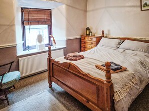 A bedroom with a wooden four-poster bed, a dresser, a chair, and a window with blinds. - 2 bedroom accommodation in Bonsall, near Matlock (Bonsall, near Matlock)