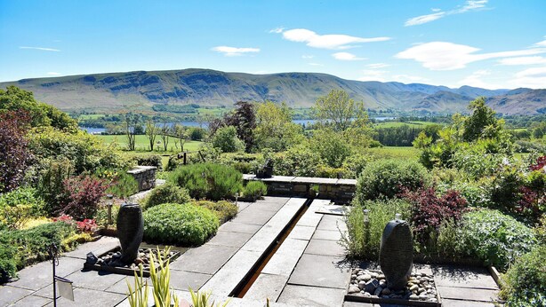 A garden pathway leading to a bench overlooking a scenic valley with mountains and a lake. - 1 bedroom accommodation in Watermillock-on-Ullswater (Watermillock-on-Ullswater)
