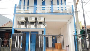A two-story building with multiple air conditioning units, a gated entrance, and a balcony. - Kamar Keluarga Bandara Mas Syariah (Tangerang)