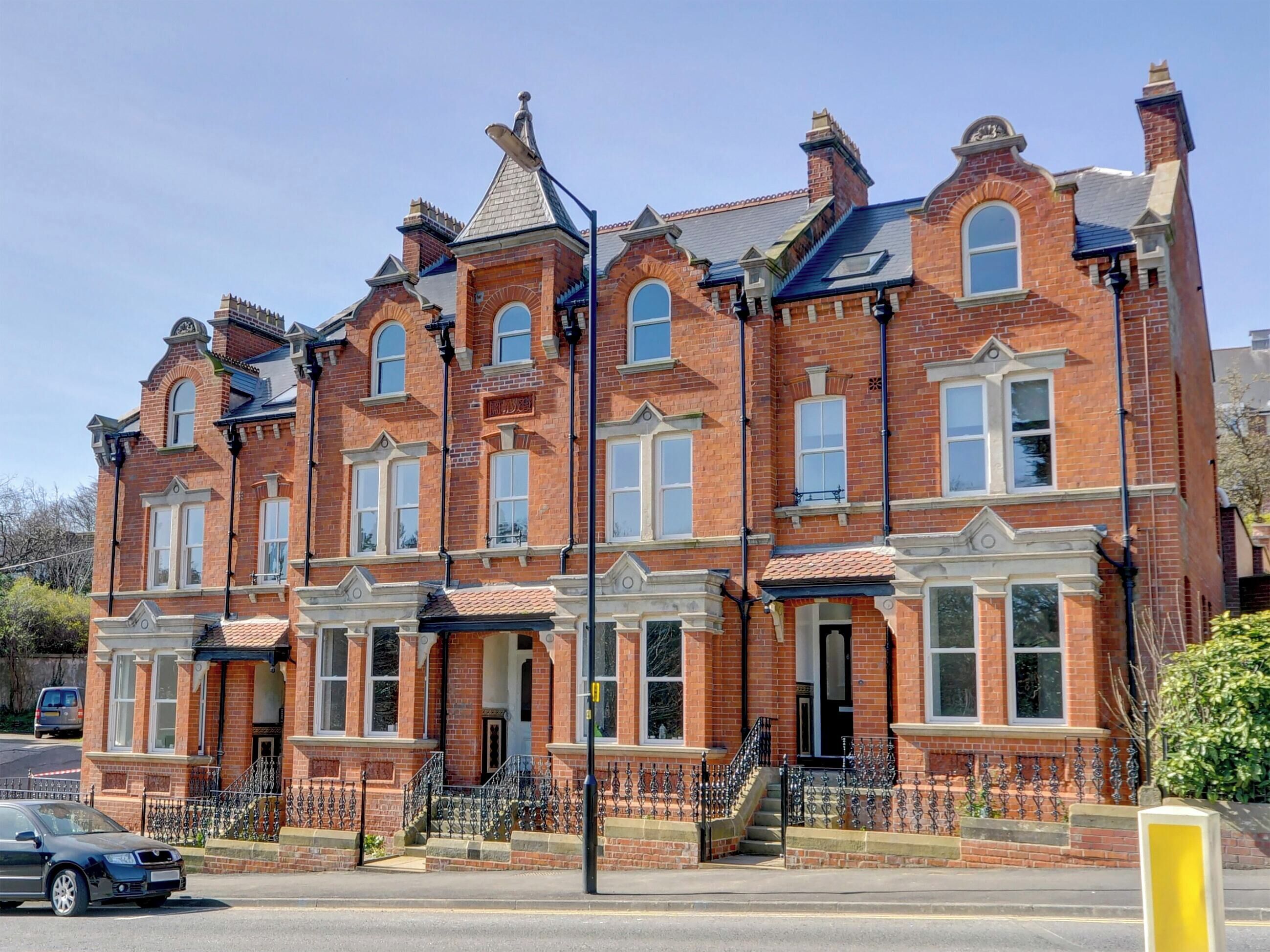A Victorian-style brick building with multiple windows and a prominent entrance.