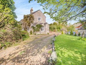 A stone house with a gravel driveway leading to a grassy lawn. - Red Squirrel Cottage (Whitwell, near Ventnor)