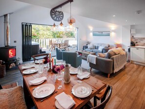 A modern living space with a dining area, a sofa set, and a kitchen. - Red Squirrel Cottage (Whitwell, near Ventnor)
