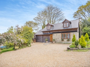 A two-story stone house with a gravel driveway, wooden shutters, and a stone chimney. - Red Squirrel Cottage (Whitwell, near Ventnor)