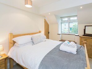 A bedroom with a bed, a window, a dresser, and a lamp. - 4 bedroom accommodation in Wardlow, near Buxton (Wardlow, near Buxton)