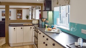 A kitchen with a central island, a window with a view, and a built-in oven. - 1 bedroom accommodation in Brede, near Rye (Brede, near Rye)