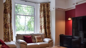 A living room with a sofa, a coffee table, and a TV. - 3 bedroom accommodation in Bakewell (Bakewell)
