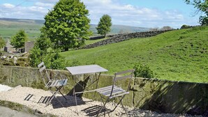 A scenic outdoor seating area with a stone wall and a view of rolling hills. - 2 bedroom accommodation in Burtersett, near Hawes (Burtersett, near Hawes)