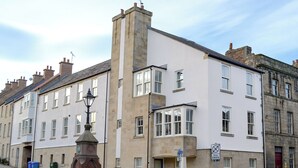 Una hilera de edificios tradicionales con un farol y un letrero que anuncia The Alnwick Ice Cream Parlour.