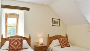 A bedroom with two single beds, a nightstand with a lamp, a window with blinds, and a framed picture on the wall. - 3 bedroom accommodation in Pedairffordd (Pedairffordd)