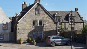 A stone building with a car parked in front.