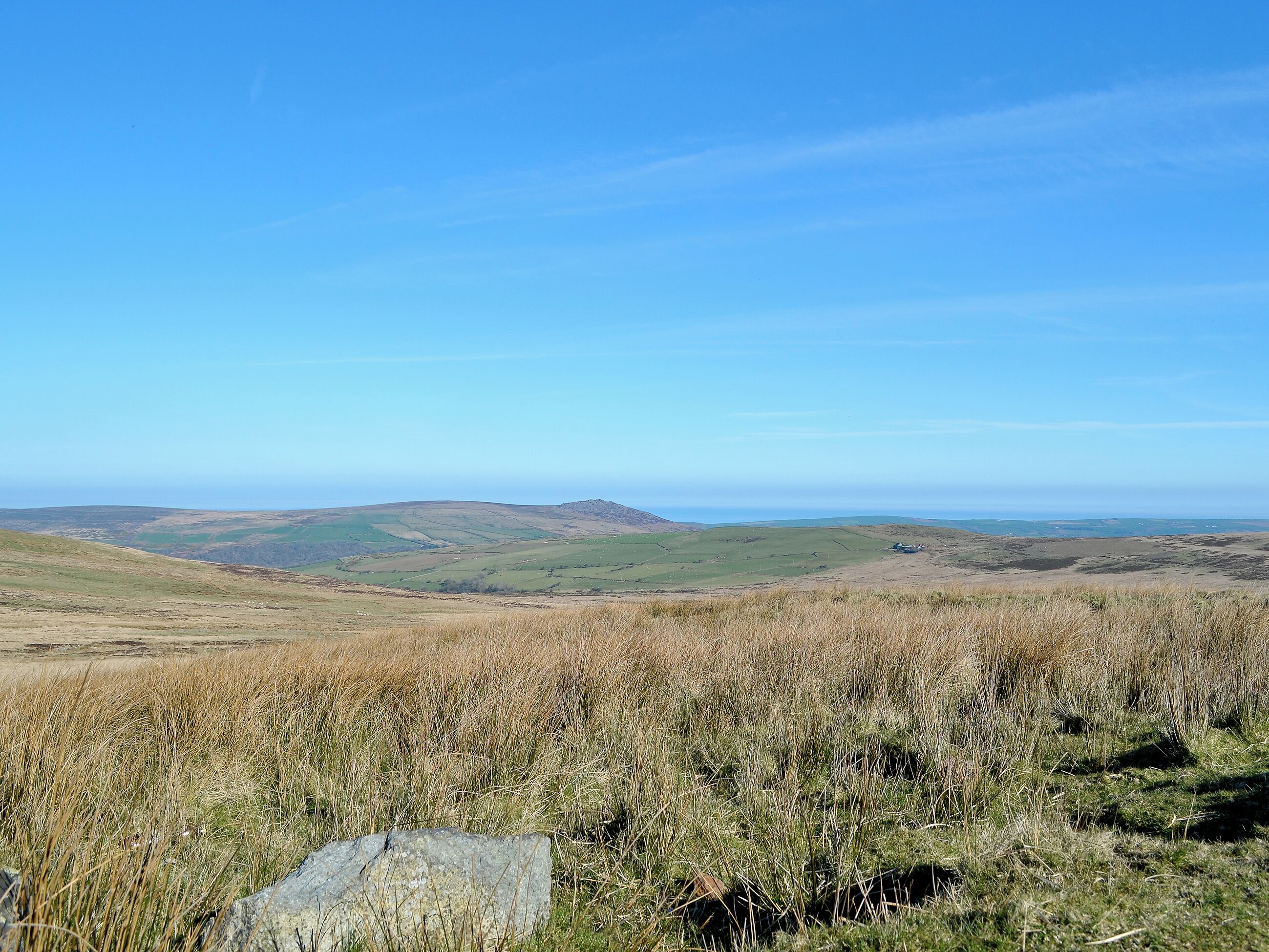 A panoramic view of a hilly landscape with a clear sky.