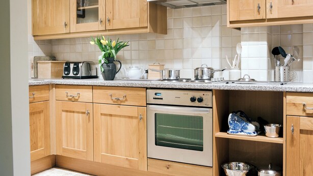 A kitchen with wooden cabinets, a stove, and a microwave.