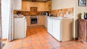 A compact kitchen with a gas stove, oven, microwave, and a dishwasher. - 2 bedroom accommodation in Catfield (Catfield)