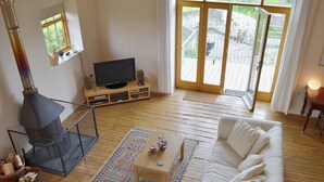 A living room with a fireplace, a sofa, a coffee table, and a television. - 1 bedroom accommodation in Burcott, Wells (Burcott, Wells)