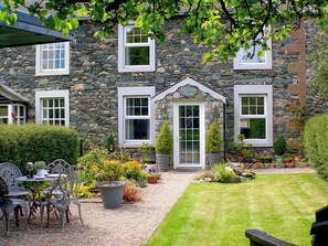 A stone cottage with a well-maintained garden, outdoor seating, and a clear view of the surrounding area. - 2 bedroom accommodation in Bassenthwaite, near Keswick (Bassenthwaite, near Keswick)