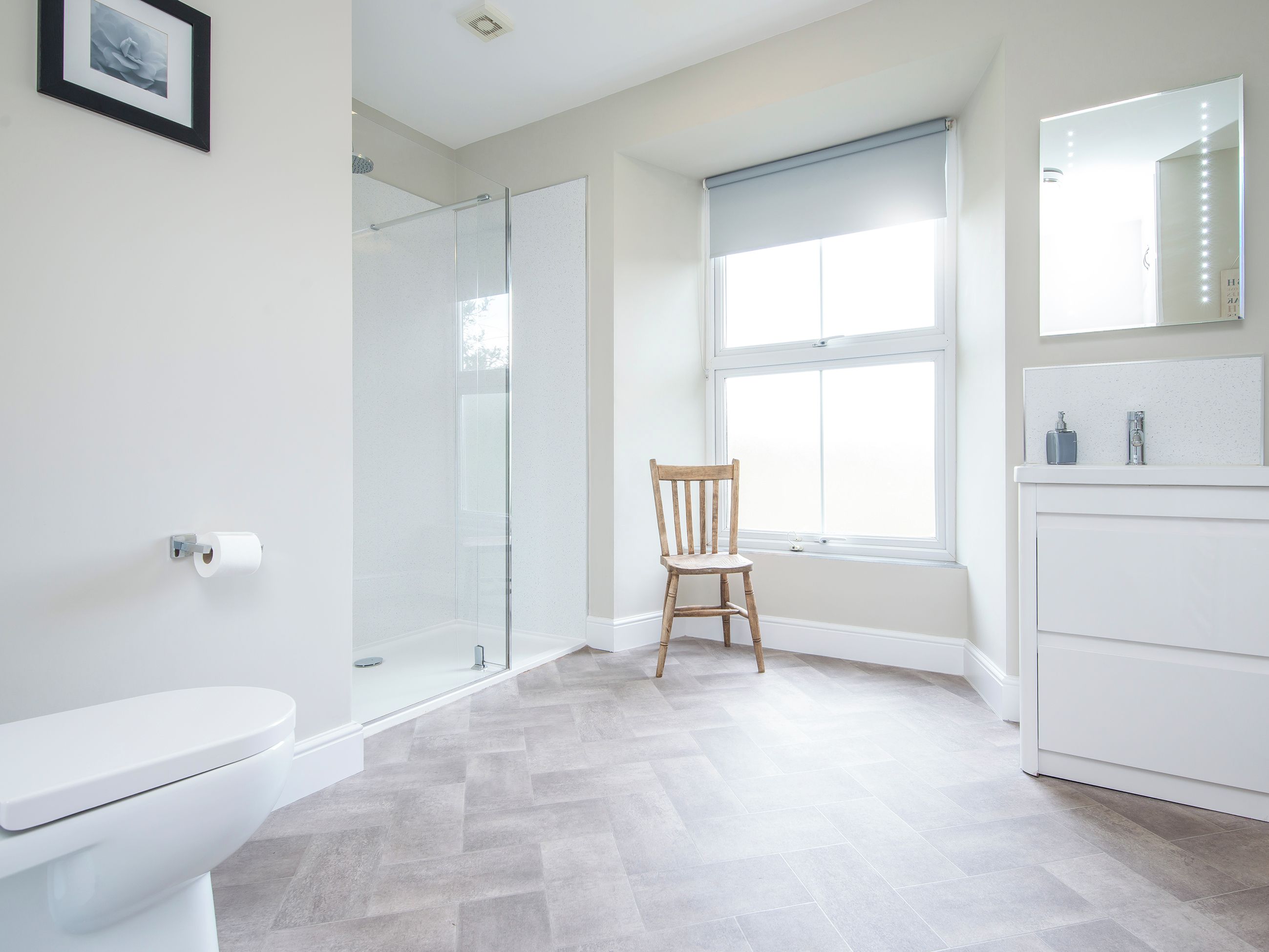 A modern bathroom with a toilet, shower, and vanity.