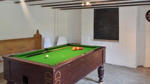 A pool table with balls, a dartboard, and a chalkboard in a room with exposed wooden beams and white walls. - 4 bedroom accommodation in Abercych, near Cardigan (Abercych, near Cardigan)