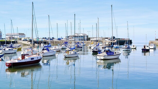 A marina with multiple boats docked, a building in the background, and calm water reflecting the boats. - 3 bedroom accommodation in Dihewyd, near Aberaeron (Dihewyd, near Aberaeron)