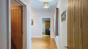 A hallway with wooden flooring, a ceiling light fixture, and a door on the left. - 3 bedroom accommodation in Dihewyd, near Aberaeron (Dihewyd, near Aberaeron)