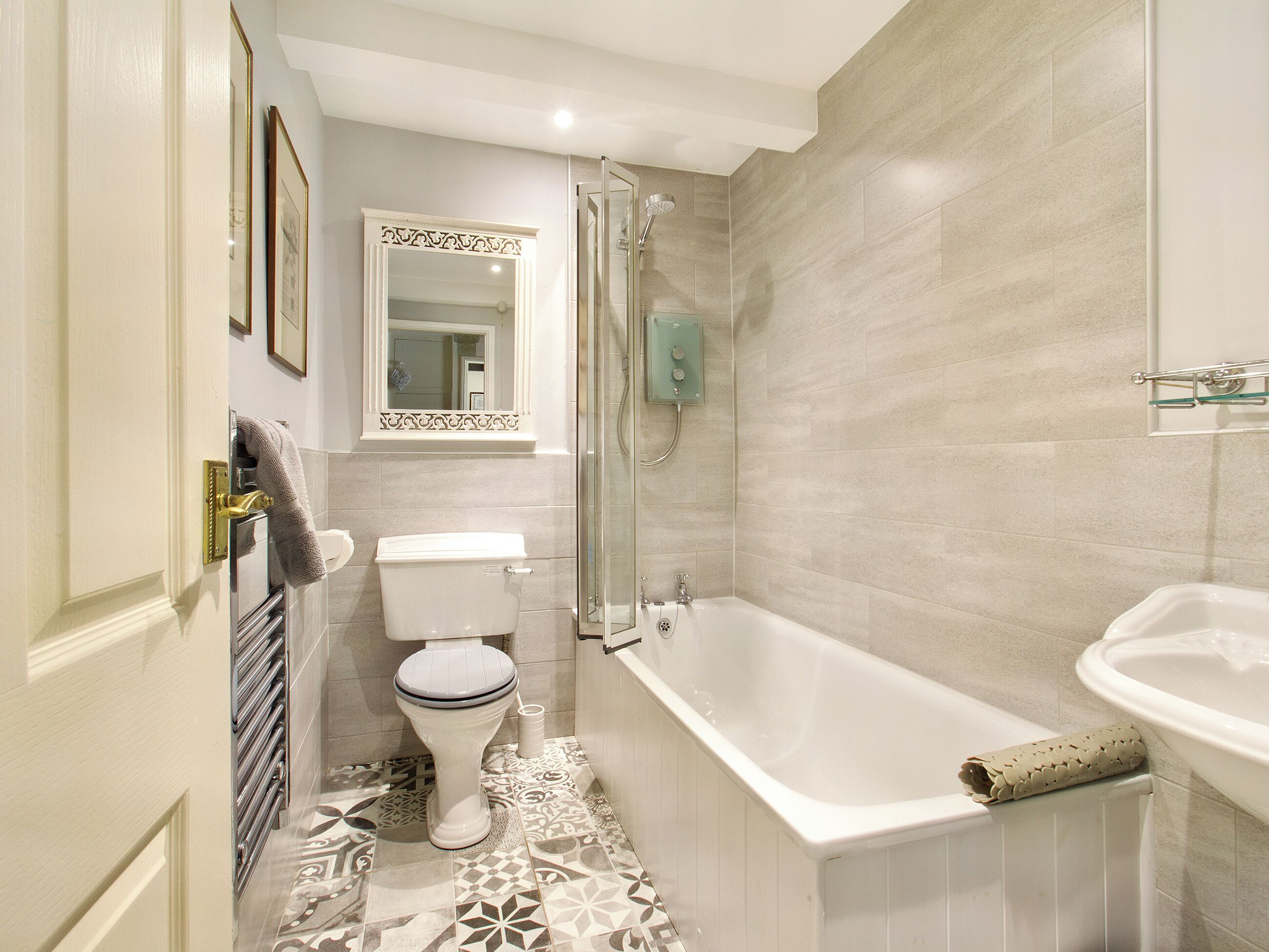Een badkamer met toilet, douche en bad.