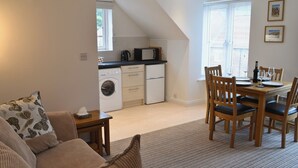 A compact living space with a kitchenette, a dining area, and a sofa. - 1 bedroom accommodation in Whitby (Whitby)