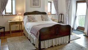 A bedroom with a wooden bed, two bedside tables with lamps, a small desk, and a chair. - 3 bedroom accommodation in Thornton Rust, near Leyburn (Thornton Rust, near Leyburn)
