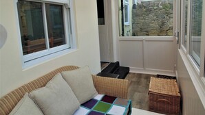 A cozy room with a wicker sofa, a colorful quilt, and a wicker basket. - 2 bedroom accommodation in Alnwick (Alnwick)