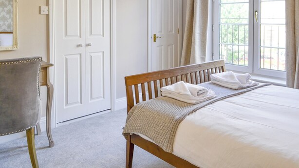 A bedroom with a bed, a chair, and two doors. - 3 bedroom accommodation in Edinburgh (Edinburgh)