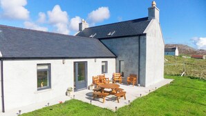 A house with a patio, a dining table, and chairs.