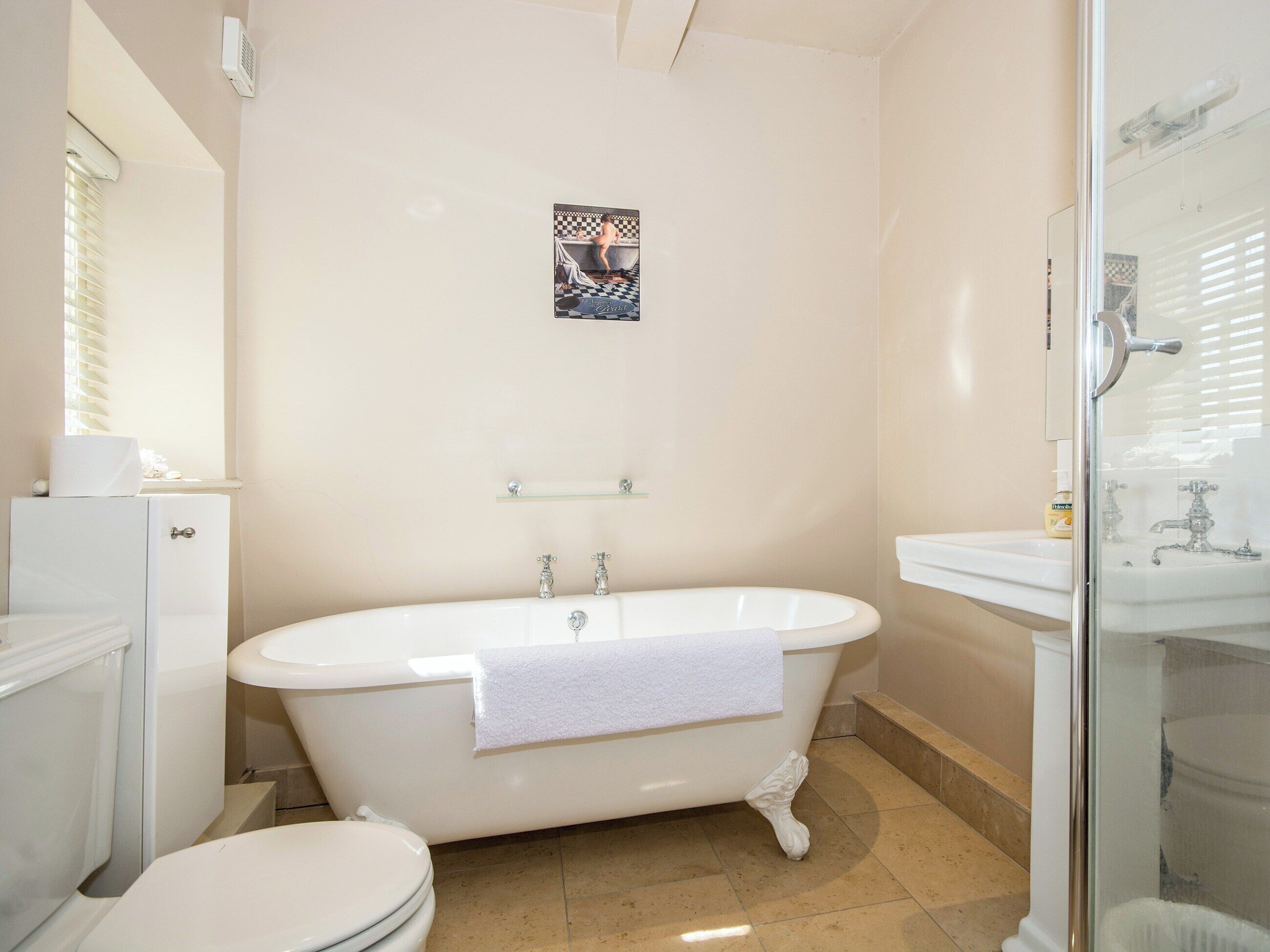 A bathroom with a freestanding bathtub, a toilet, and a glass-enclosed shower area.