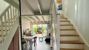 Un pasillo amplio con una escalera que conduce a un comedor.