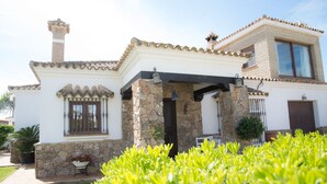 Une maison à deux étages avec une façade en pierre, un toit en tuiles et un balcon.