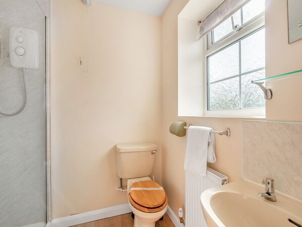 Une salle de bain équipée de toilettes, d’une douche et d’une baignoire.