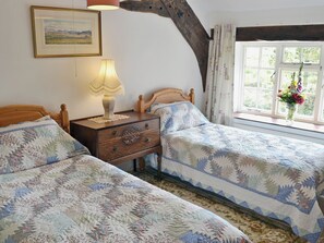 A bedroom with two beds, a nightstand, a lamp, a framed picture, and a window with curtains. - 2 bedroom accommodation in Near Ulpha (Near Ulpha)