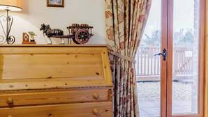 A wooden dresser with multiple drawers, a lamp, and decorative items on top. - Timbers Barn - E3863 (Runcton Holme)