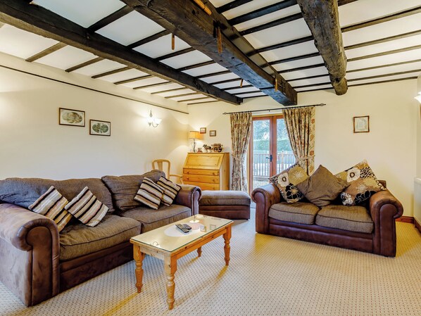 A cozy living room with two brown leather sofas, a wooden coffee table, and a wooden cabinet.