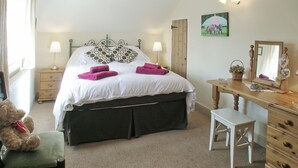 A bedroom with a bed, bedside tables, a desk, a chair, and a teddy bear. - 2 bedroom accommodation in Bridge, near Chard (Bridge, near Chard)