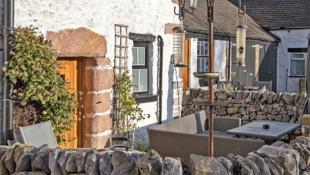 A stone wall, a wooden door, and a stone fountain. - Lavender Cottage - UK4061 (Buxton)