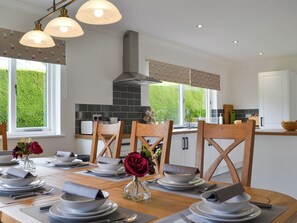 A modern kitchen with a dining area set for a meal. - 4 bedroom accommodation in Keswick (Keswick)