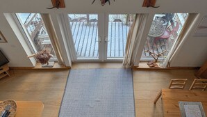 A room with a large window, a ceiling-mounted deer head, and a wooden floor. - Stob-Ban View - S4582 (Achintee, Fort William)