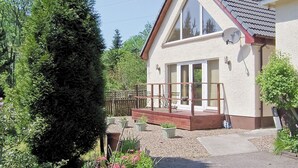 A two-story house with a balcony, large windows, and a garden area. - Stob-Ban View - S4582 (Achintee, Fort William)